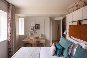 爱丁堡仕骅廷荷里路德艾比史坦公寓酒店的一间卧室配有一张带蓝色枕头的床和一张书桌