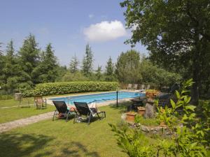 拉达-因基安蒂Belvilla by OYO Villa Ulivo的一个带椅子的庭院和一个游泳池