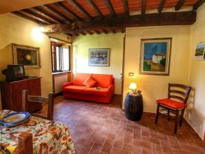 拉达-因基安蒂Belvilla by OYO Villa Ulivo的客厅配有红色的沙发和桌子
