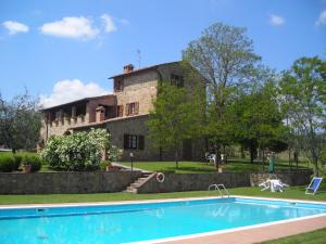 蒙特普齐亚诺Agriturismo Casagrande的一座古老的房子,前面设有一个游泳池