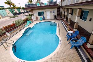 好莱坞加勒比海度假宾馆的一座带两把蓝色椅子的大型游泳池和一座建筑