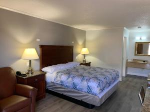 纽波特纽斯Motel 6 Newport News, VA – Fort Eustis的一间卧室配有一张床、一把椅子和两盏灯。