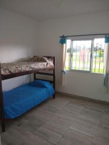 Campo QuijanoQuijaneando的一间卧室设有两张双层床和一扇窗户。