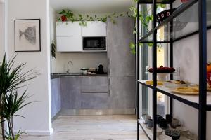 米兰B&B La Terrazza di Barbara的一间小厨房,配有白色的橱柜和柜台