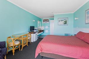 斯旺西Swansea Motor Inn Tasmania的一间卧室配有一张床、一张桌子和一张书桌
