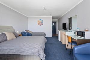 斯旺西Swansea Motor Inn Tasmania的酒店客房带一张床和一个厨房