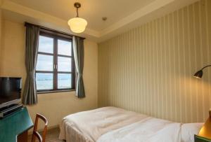 长滨市格拉兹奇塔比瓦克酒店的一间卧室配有一张床、一张书桌和一个窗户。