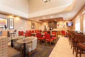 圣达菲圣达菲康福特套房酒店的一间带桌椅的餐厅和一间酒吧