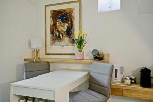 多维尔Pegase的一张带两把椅子的白色桌子和墙上的一幅画
