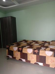 古瓦哈提Woodland Lodge and Restaurant的一间卧室配有一张床铺,床上有毯子