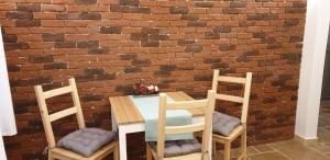 曼加利亚Cella Deluxe的砖墙前的桌椅