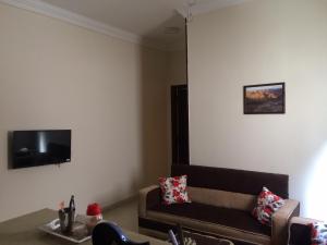 马萨阿拉姆Lady Queen Apartment的客厅配有沙发和墙上的电视