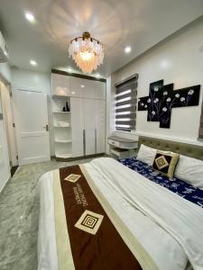 海防Khanh Phong Homestay Venice 21-12 Vinhomes Imperia的一间卧室配有一张大床和一个吊灯。