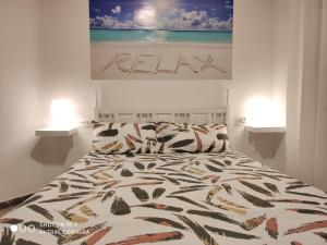卡拉费尔CALAFELL 5 BEACH的卧室内的一张床位,配有两盏灯和一幅画