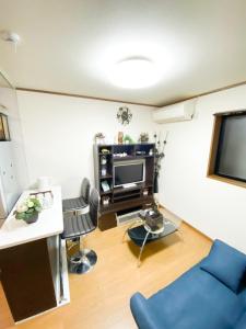 大阪Osaka Nipponbashi Doutonbori Family House的客厅配有蓝色的沙发和电视