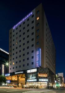 仙台仙台大和鲁内酒店的一座酒店大楼,上面有 ⁇ 虹灯标志