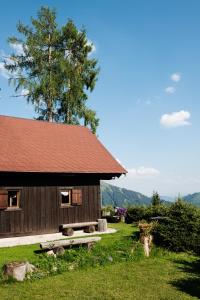 皮恩山口附近施皮塔尔Jagdhütte Gammeringalm的小木屋前面设有长凳