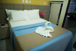 科鲁里皮Hotel Litoral Sul的卧室里一张床上的白色天鹅