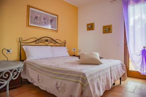 坎丕里亚麦利蒂玛丹尼斯别墅酒店的一间卧室配有一张床、一张桌子和一个窗户。