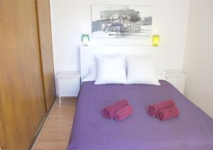 巴塞罗那卡尔德欧雷萨公寓的床上有两张红色拖鞋