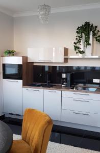 凯撒斯劳滕Bismarck-Apartment的厨房配有白色橱柜和椅子