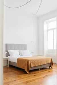 波尔图O da Joana的白色卧室设有一张大床和木地板