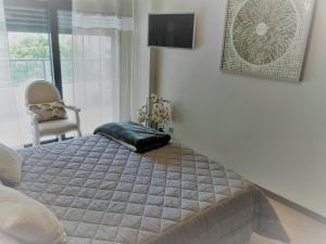 波尔蒂芒Apartamento de Luxo na Praia的卧室配有床、椅子和窗户。