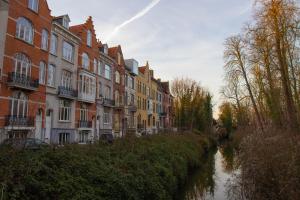 布鲁日VEGAN, PLANT BASED b&b central Bruges的河边一排房屋,有建筑物