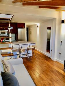 马德里CHUECA Apartamentos的一间带白色沙发的客厅和一间厨房