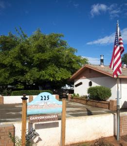 佩吉Canyon Colors Bed and Breakfast的一座悬挂美国国旗的建筑前的标志