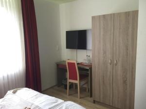 特罗斯多夫Central Hotel的一间卧室配有书桌、一张床和一个橱柜