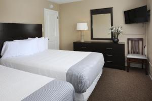 怀尔德伍德Aquarius Oceanfront Inn的酒店客房,设有两张床和镜子