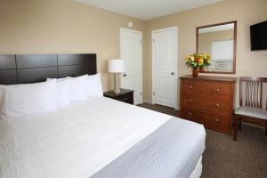 怀尔德伍德Aquarius Oceanfront Inn的一间卧室配有一张床、梳妆台和镜子