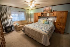 佩吉Canyon Colors Bed and Breakfast的一间卧室配有一张床、一把椅子和吊扇