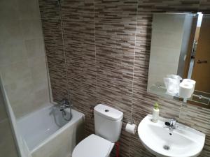 马德里考特罗托雷斯公寓的浴室配有白色卫生间和盥洗盆。