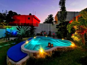 巴利亚多利德Mayan Majesty Boutique Hotel的一个带灯的游泳池,位于带房子的院子内