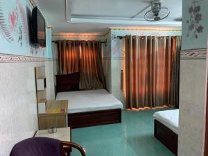 胡志明市Minh Tuan Hotel的小房间设有两张床和电视