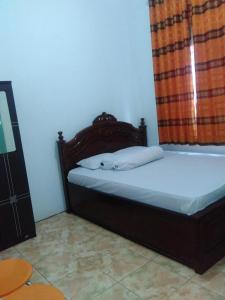BaubauWisma Kahyangan的一间卧室配有一张带木制床头板的床