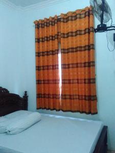 BaubauWisma Kahyangan的一间卧室配有床和窗帘