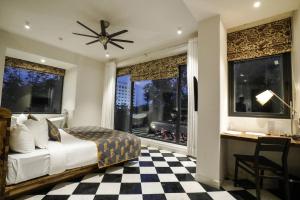 斋浦尔Brij Nest, Jaipur - An All Suite Boutique Hotel的卧室配有一张床、一张书桌和窗户。