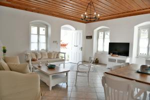 伊兹拉Hydra's Pearl - White Pearl的客厅配有白色家具和平面电视