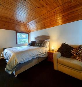 莫法特Groom's Cottage的一间卧室配有一张床和一个沙发