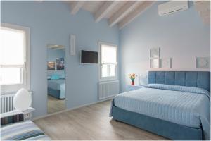 布拉诺岛Tiffany Home的一间蓝色卧室,配有一张床和镜子
