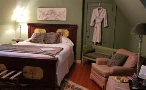 AppomattoxLongacre of Appomattox的卧室配有一张床,墙上挂着长袍