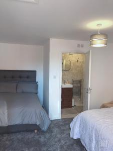 诺丁汉Flat 1 - Entire Modern Studio with en-suite and free Parking close to QMC, City centre & Notts Uni的一间卧室配有一张床,浴室设有水槽