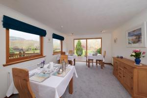 德拉姆纳德罗希特Woodlands Bed & Breakfast的用餐室设有2张桌子和2个窗户
