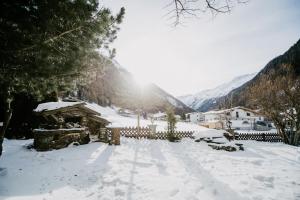 索尔登阿尔盆黑姆西蒙娜酒店的一座有房子和山脉的雪盖庭院