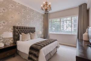 约翰内斯堡Modern Apartment in Rosebank的一间卧室设有一张大床和一个窗户。