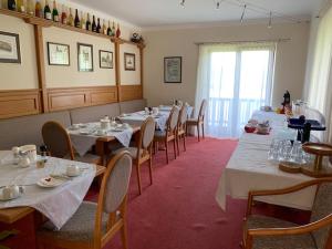 赖弗尼茨Hotel Garni Haus am Wald的一间带长桌子和椅子的用餐室以及窗户。