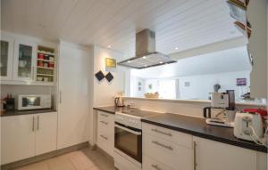 ØksenmølleBeautiful Home In Ebeltoft With Kitchen的厨房配有白色橱柜和炉灶烤箱。